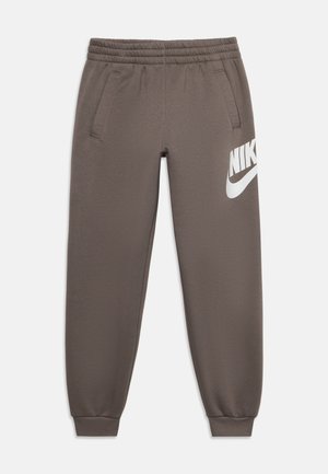 Pantalon de jogging marron Nike avec taille et poignets élastiques, poches latérales et un grand logo blanc Nike sur la partie supérieure de la cuisse gauche.