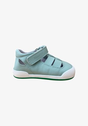 Zapato de cuero para niño pequeño en color azul claro con una correa de Velcro, lados abiertos y suela de goma blanca. Cuenta con una parte superior texturizada y un diseño perforado.