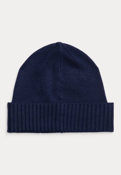Navy knitted beanie with a ribbed cuff and smooth top. Flexible fabric with a uniform texture, suitable for casual wear in cooler weather.