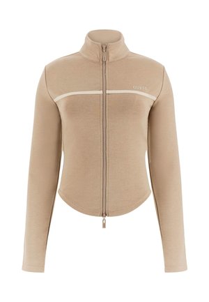 Béžová bunda na zips s dlhými rukávmi a vysokým golierom, biely horizontálny pruh cez hrudník a logo "GUESS" na ľavej strane.