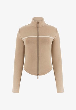 Béžová bunda na zips s dlhými rukávmi a vysokým golierom, biely horizontálny pruh cez hrudník a logo "GUESS" na ľavej strane.