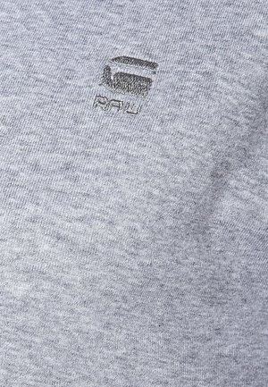 Grå bomulds t-shirt med et subtilt broderet logo med "RAW" og et geometrisk design. Blød tekstur og afslappet pasform.