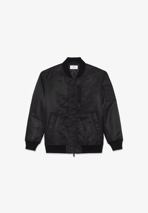 Musta pommikurta, jossa on satiiniviimeistely, ribattu kaulus ja hihansuut, vetoketjuluukku ja kaksi sivutaskua. Varustettu läpyskillä vasemmassa hihassa.