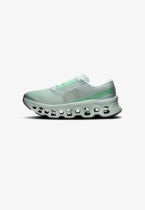 Chaussure de running gris clair et verte avec une semelle évidée et le texte "ON RUNNING" sur le côté, vue de l'extérieur.