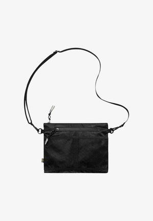 Czarna torba na ramię o fakturowanej powierzchni, regulowanym pasku, górnym zapięciu na zamek oraz wielu komorach do organizacji.