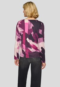 Langärmeliger, mehrfarbiger Pullover in Rosa-, Lila- und Dunkelgrautönen mit abstraktem Muster. Weiche Textur, figurbetontes Design und Rundhalsausschnitt.