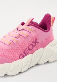 Sneaker rosa con tomaia in tessuto a rete, disponibile in tonalità di rosa chiaro e scuro. Suola bianca spessa con dettagli testurizzati. Logo "GEOX" visibile.