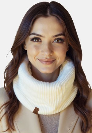 Weißer gerippter Strickschal mit Rollkragen und weicher Textur, mit einem kleinen braunen Etikett; getragen über einem beigen Pullover und Mantel.