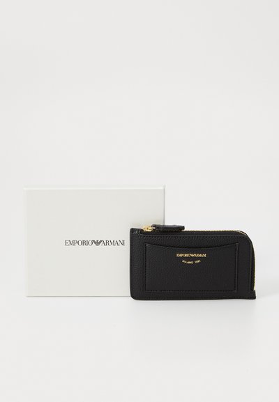 Portofel negru din piele cu suprafață texturată, accesorii aurii și închidere cu fermoar. Însoțit de o cutie albă cu logo-ul Emporio Armani.