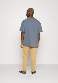 Nike Sportswear CLUB JGGR - Tracksuit bottoms - gold-coloured