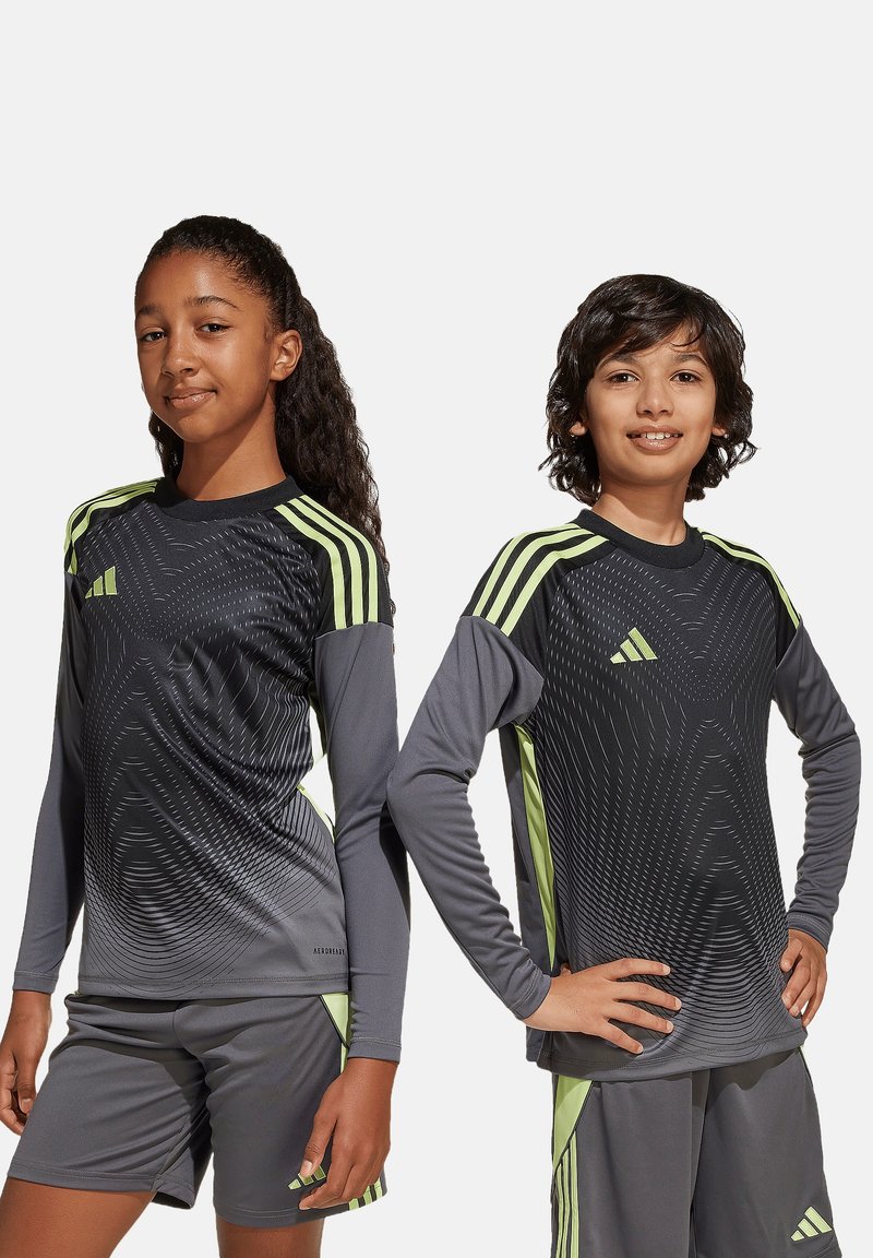 T-shirts de sport à manches longues en noir avec un motif dégradé gris et des accents vert néon. Ensemble porté avec un short assorti dans des couleurs similaires.