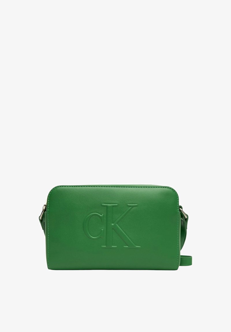 Borsa a tracolla verde in pelle con logo "CK" impresso, forma rettangolare, chiusura con zip e tracolla regolabile. Texture liscia, design minimale.