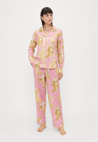 Conjunto de pijama rosa com blusa abotoada e calças folgadas, apresentando padrões dourados de figuras e desenhos florais, feito de um tecido suave.