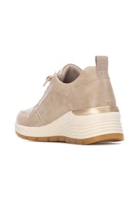 Zapatilla beige con parte superior de ante texturizado, media suela blanca contrastante, acento dorado en el talón y una tira en la parte posterior.