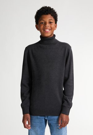 Dunkelgrauer Rollkragenpullover aus Strickstoff, mit langen Ärmeln und gerippten Bündchen und Saum. Kombiniert mit blauen Jeans.