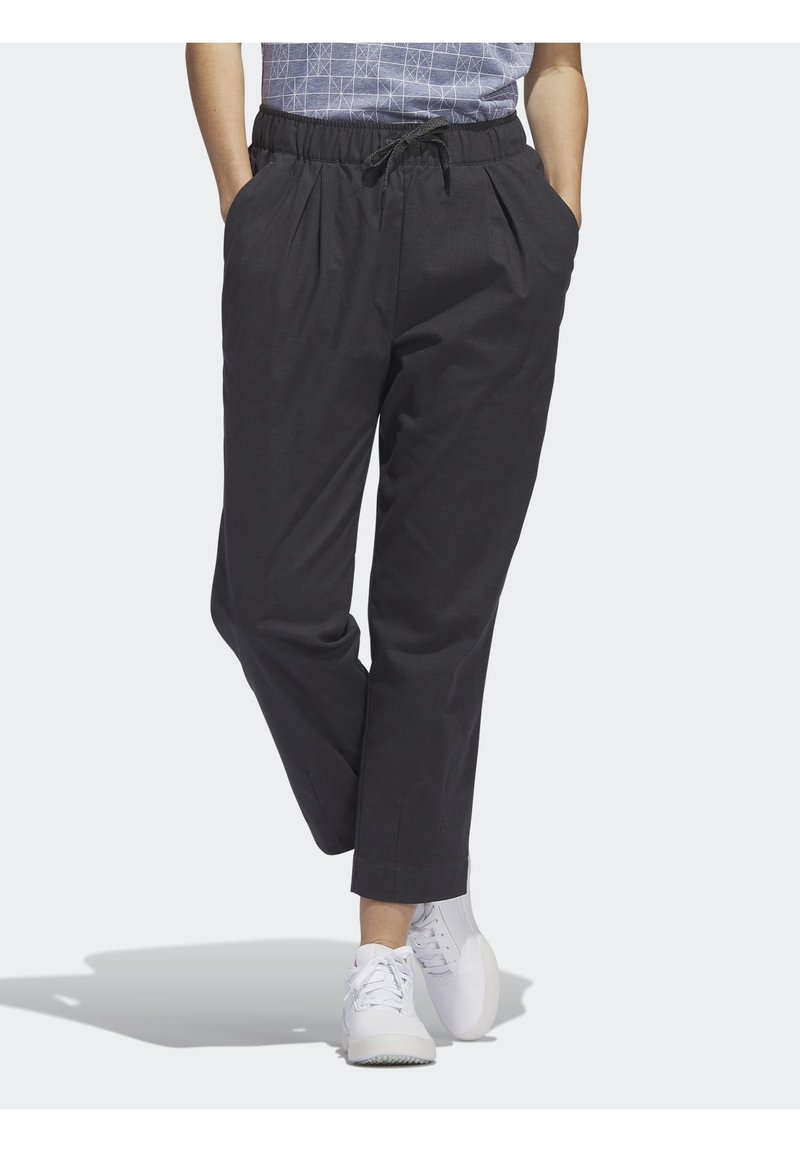 Tummanharmaat, löysät housut, joissa on joustava vyötärönauha ja kiristysnauha, sivutaskut ja kapeaksi kapenevat lahkeet.