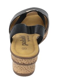 Zwarte leren sandaal met een ronde teen, kurkachtige platform, gevoerde binnenzool en elastische banden voor een veilige pasvorm.