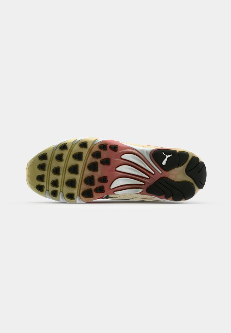 Baskets avec une semelle en caoutchouc multicolore au motif texturé. Les couleurs principales sont le jaune, le rouge et le noir. Le design comprend un bout rond et un logo.