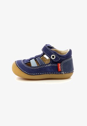 Scarpa in camoscio blu navy con suola in gomma, cinturino regolabile e design con ritagli. Presenta accenti azzurri e dettagli di cucitura bianca.