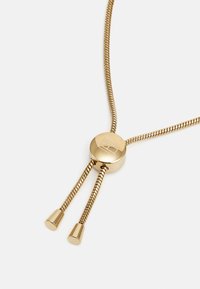 Collana in oro con una catena elegante e flessibile e una chiusura circolare. La catena ha due estremità filettate con punte arrotondate.