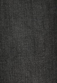 Gros plan d'un tissu en denim gris foncé montrant une texture de tissage diagonal détaillée.