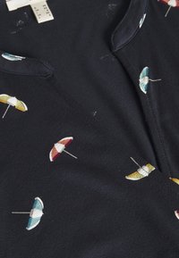 Niebieska tkanina koszulki z dekoltem w szpic, z motywem kolorowych parasoli plażowych w kolorach czerwonym, zielonym, żółtym i niebieskim. Gładka tekstura.