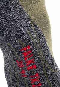 Nærbillede af en grå og oliven struktureret sok med røde bogstaver, der står "THINKEAK 39-44", strikket ind i stoffet.