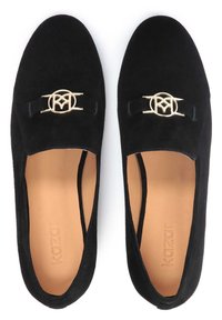 Scarpe slip-on in suede nero con design piatto, caratterizzate da un accento del logo in tonalità oro sul davanti e da una soletta in pelle liscia.