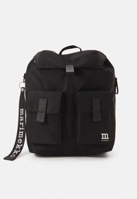 Mochila preta feita de tecido durável, com design de topo enrolável, dois bolsos frontais e um emblema com o logótipo. Alças ajustáveis e fecho de correr.