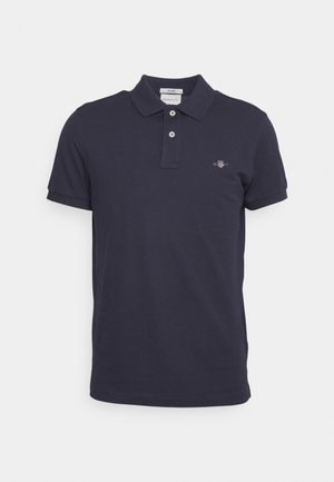 Polo bleu marine en coton, avec un col classique, une patte de boutonnage à deux boutons et un petit logo brodé sur la poitrine.