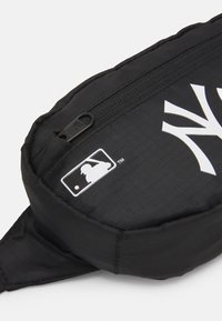 Marsupio nero in nylon con finitura texturizzata, caratterizzato da un design con logo bianco e una chiusura con zip per una conservazione sicura.