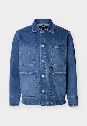 Kék farmer anyagú gombos dzseki, négy elülső felvarrt zsebbel és gallérral, egyszerű világos háttéren bemutatva.