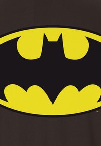 Black t-shirt featuring a large, yellow Batman logo with a prominent bat shape and curved wings, set against a dark background.