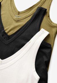 Trois débardeurs sans manches avec col en V empilés, couleurs blanc, noir et vert olive, posés à plat sur un fond blanc.