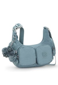 Blå nylon axelväska med två framfickor, prydd med en lurvig charm och texturerad rem. Dragkedjor och metallkomponenter för stängning.