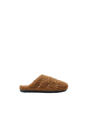 Chausson marron en polaire à enfiler avec surpiqûres décoratives croisées et semelle en caoutchouc noir, présenté en profil latéral.
