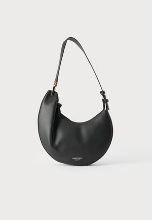 Sac à bandoulière en cuir texturé noir en forme de croissant avec bandoulière réglable et petit logo argenté près de la base sur fond uni.