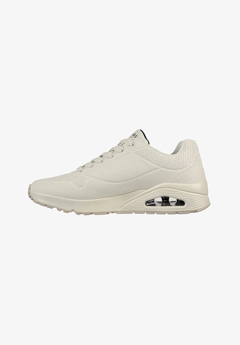 White athletic shoes with a smooth leather upper, perforated accents, a cushioned sole, and a visible air unit in the heel for added comfort.