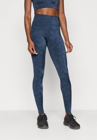 Colanți bleu marin cu un model subtil de piele de șarpe, design cu talie înaltă, realizați dintr-un material elastic, având o textură fină și detalii de cusătură.