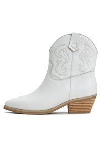 Botas de vaquero de cuero blanco con punta puntiaguda, costuras decorativas en el tubo y tacón de madera apilada. Textura suave en toda su superficie.