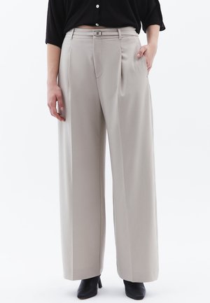 Beige wijde broek met een hoge taille, voorplooien en een klein zilveren gespdetails op de gordellus. Soepele stof, strakke lijnen.