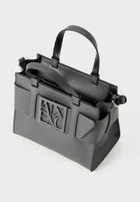 Tumši pelēkas krāsas ādas rokassoma ar divām rokturiem, ārējām sānu kabatām, rāvējslēdzēja aizdari un izteiksmīgu A|X Armani Exchange logotipu priekšā.