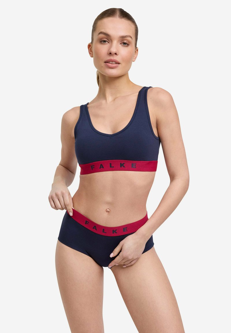Brasile sportivo blu navy e slip coordinato con un elastico rosso. L'elastico presenta il logo "FALKE". Texture liscia, materiale elasticizzato.