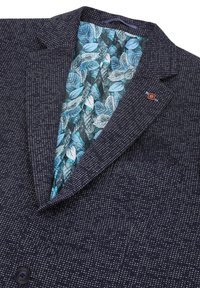 Blazer navy con un motivo testurizzato, chiusura a un bottone. Foderato con un tessuto a stampa di foglie blu. Presenta un piccolo logo rosso sul risvolto.