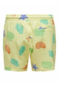 Bañadores amarillos con una superficie texturizada, que presentan coloridos patrones marinos en verde, azul, naranja y púrpura. Incluye una cintura elástica.