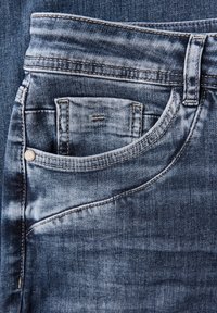 Blauwe denim jeans met een voorzak, met een vervaagd ontwerp, zichtbare stiksels en een metalen knoopaccent. Gladde textuur.