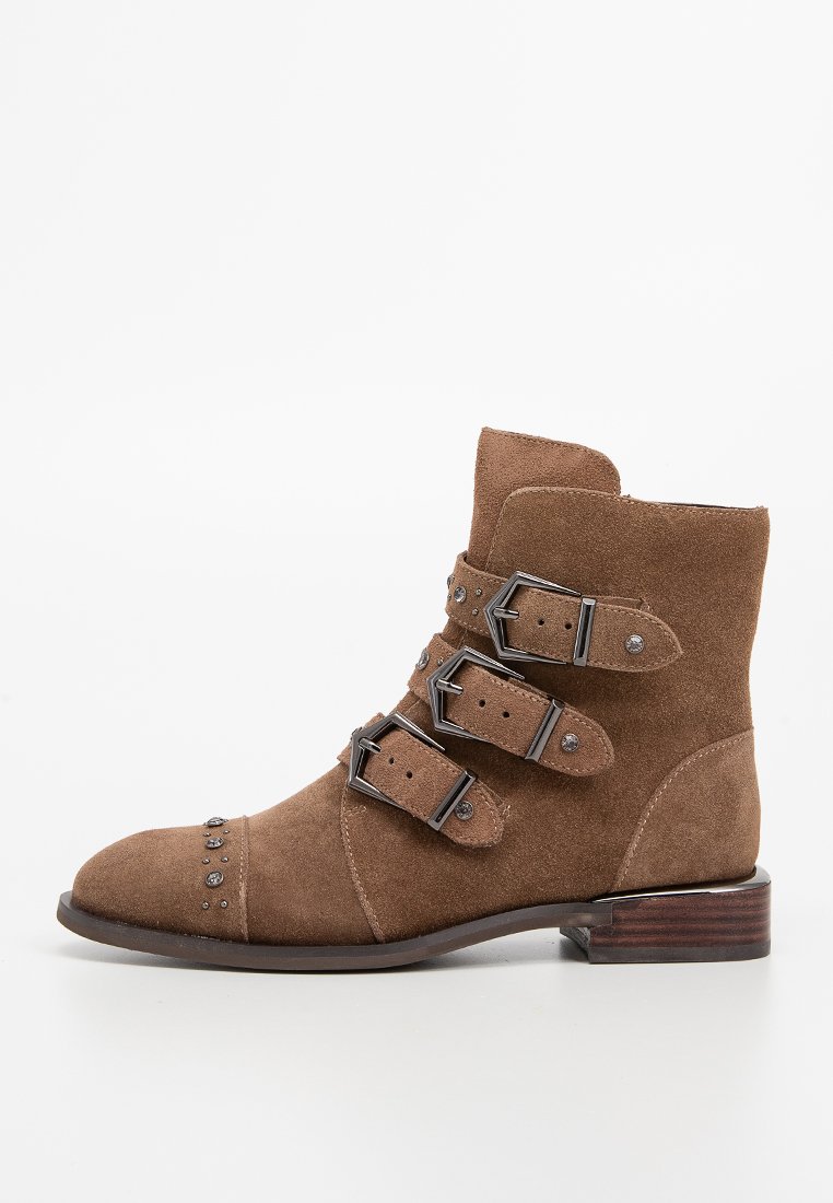 Stivaletti in suede marrone con tre cinghie a fibbia, dettagli in metallo argentato, punta rotonda e tacco basso impilato.