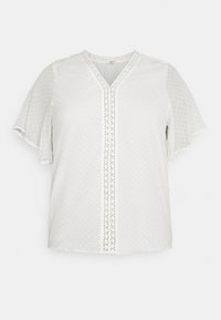Hvid bluse med korte ærmer og V-hals, med et prikmønster og blonder trim langs forsiden. Let og glat tekstur.