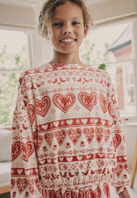 Rot-weißer Pullover mit Mustern von Herzen, Vögeln und Blumenmotiven, elastischem Saum und weichem Stoffgefühl.