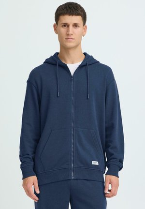 Felpa con cappuccio blu navy con zip frontale, cappuccio con coulisse, tasche a marsupio sul davanti, polsini e orlo a coste. Realizzata in tessuto morbido con texture liscia.